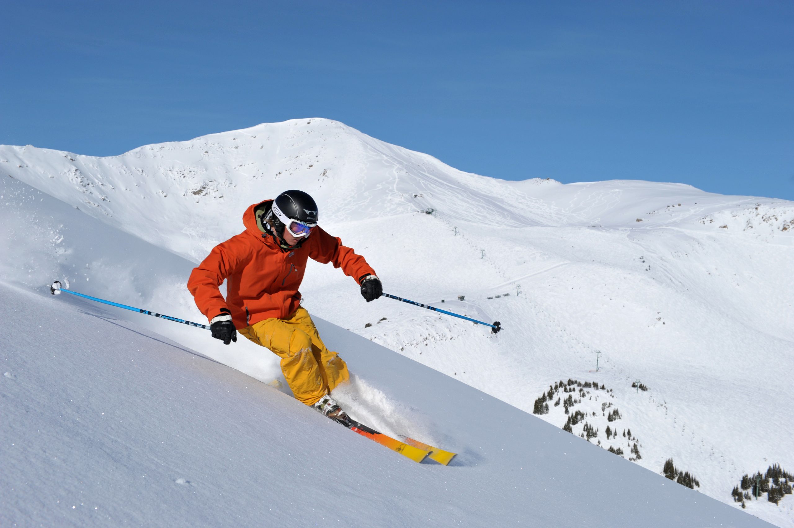 Лыжник скатывается. Горнолыжный спорт. Спуск на горных лыжах. Лыжник в горах. Горнолыжник на склоне.